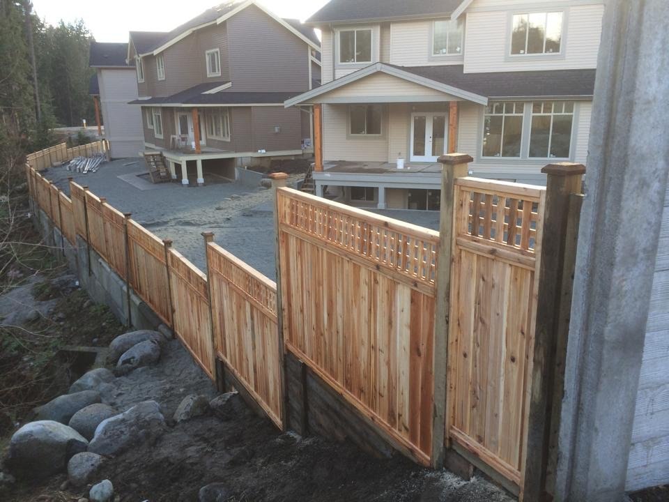 Cedar privacy panels with lattice tops stepping along a slope; LS project in the Fraser Valley.