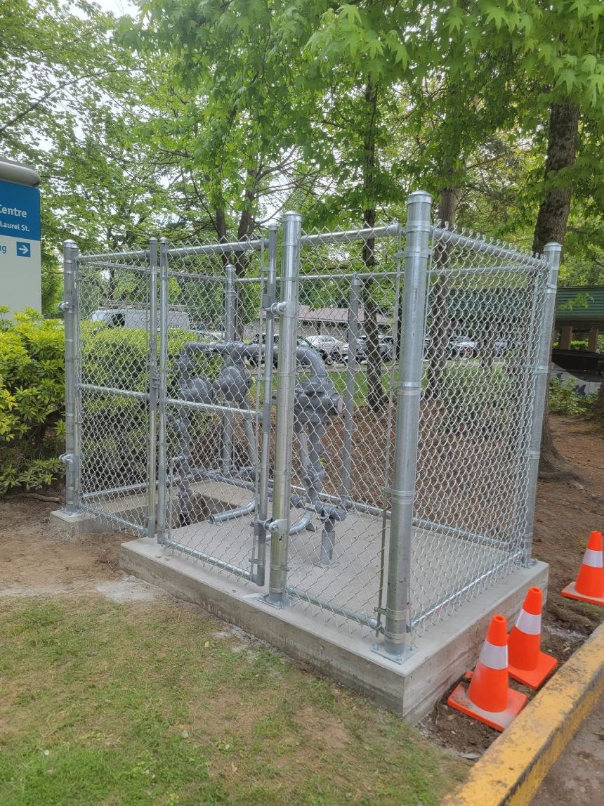 Chain-link enclosure around utility equipment; LS project in the Fraser Valley.