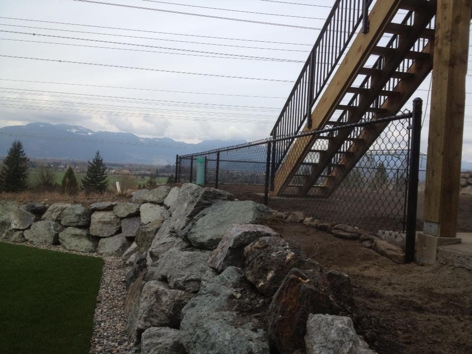Black chain link following hillside ground; LS project in Chilliwack.