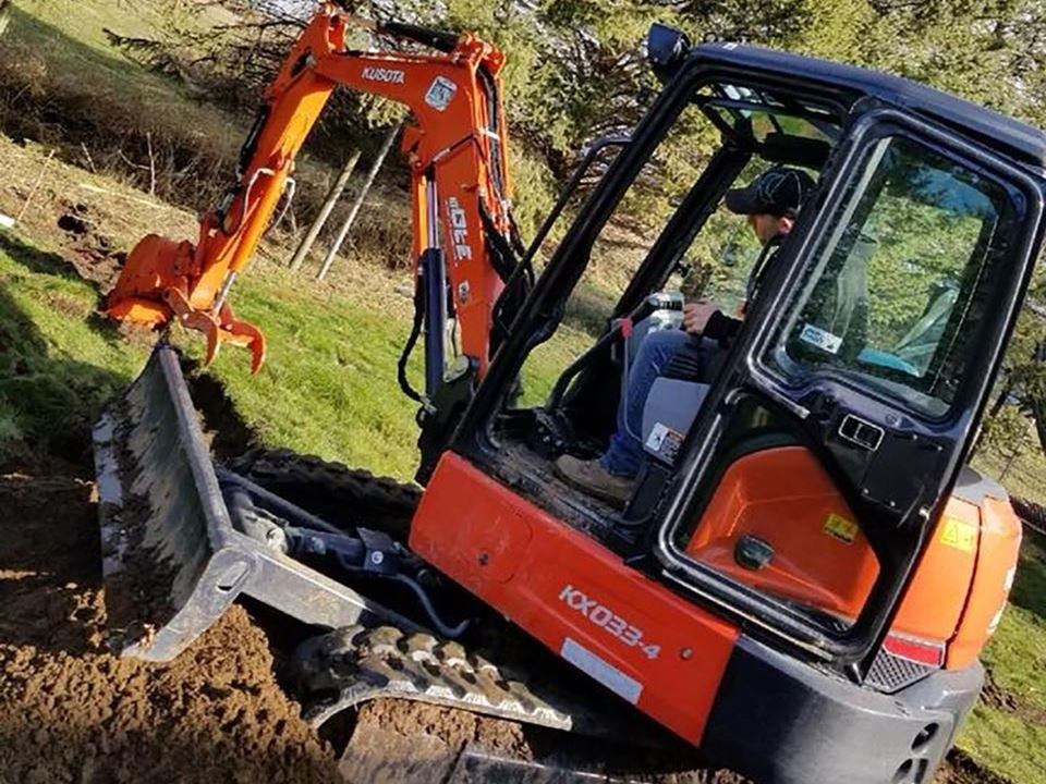 Mini excavator working along a post line; LS project in the Fraser Valley.