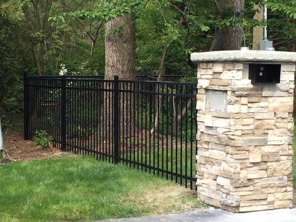 Powder-coated ornamental steel beside a stone column; LS project in Chilliwack.
